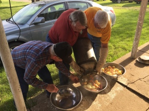 The men pouring out the food prepared in a milk can. Delicious!
